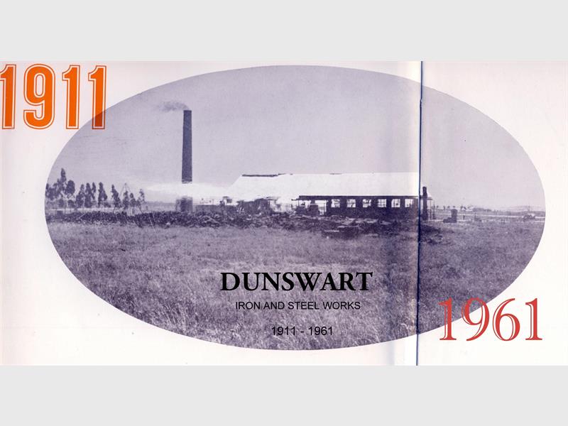 A black and white image taken from afar of Dunswart Iron and Steel Works in 1911 with the date 1911 in orange on the side of the image.
